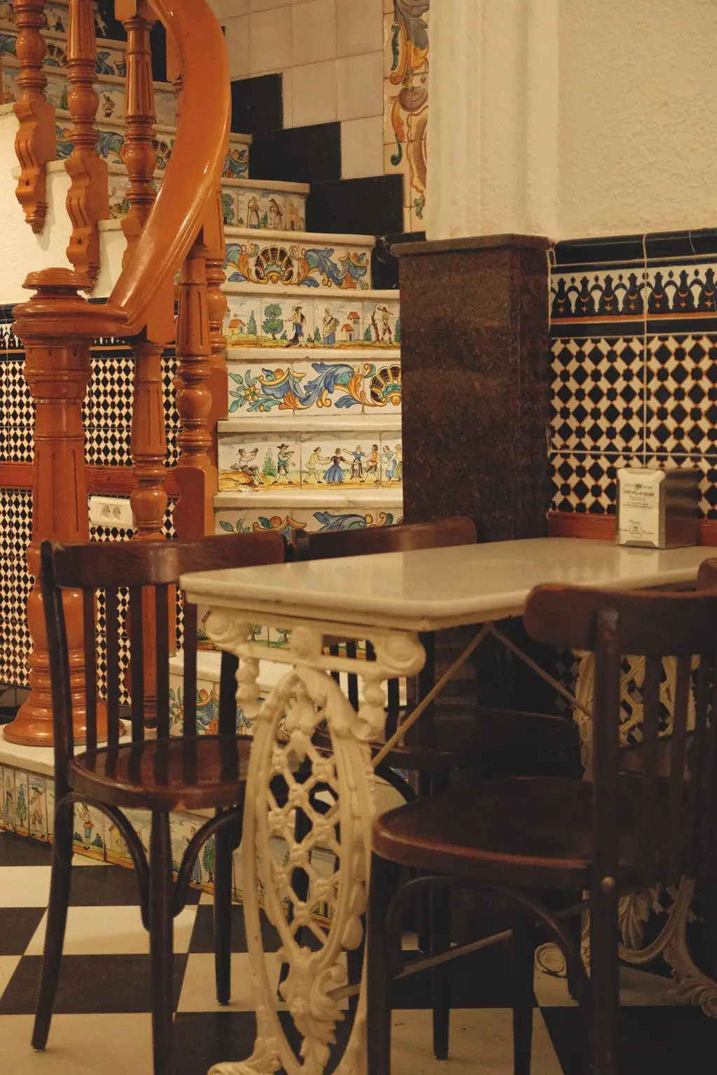 Interior de un café tradicional con azulejos y mesa de mármol